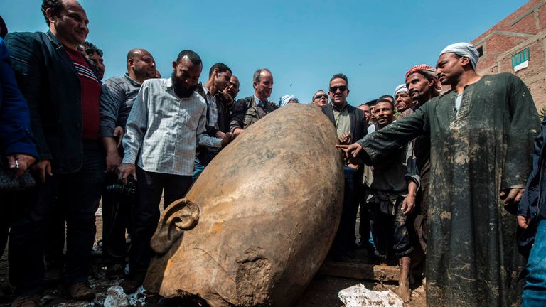 Egyptian minister of antiquates Khaled el-Anani posing with the head of a statue found in a Cairo slum